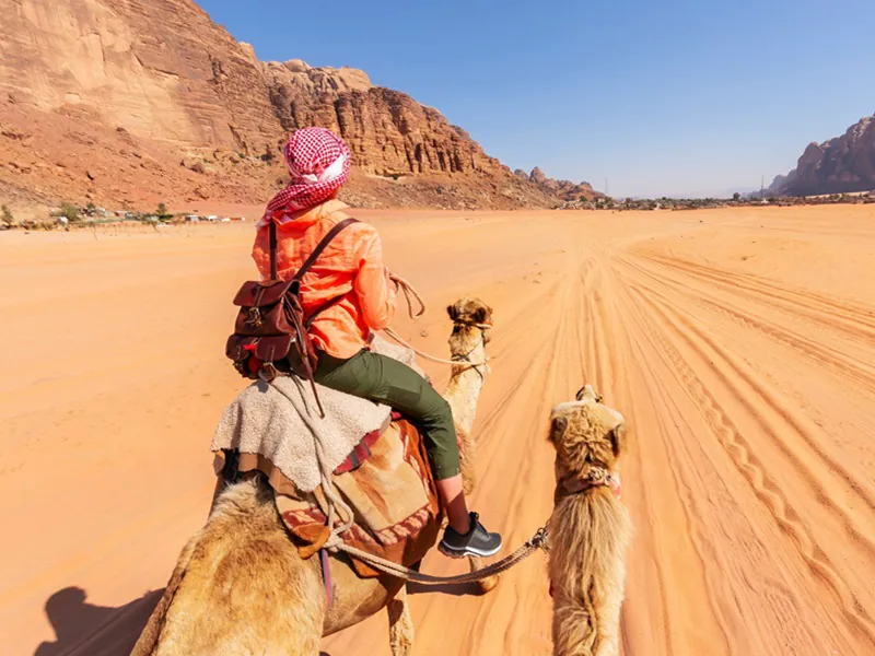 Turist på kamel i Wadi Rum